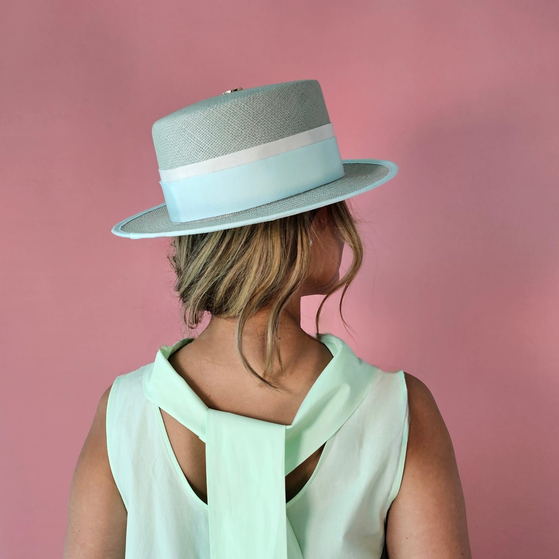 Back view of ALMA seafoam green Panama hat with gold logo emblem