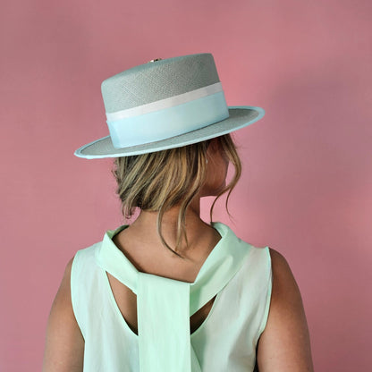Back view of ALMA seafoam green Panama hat with gold logo emblem