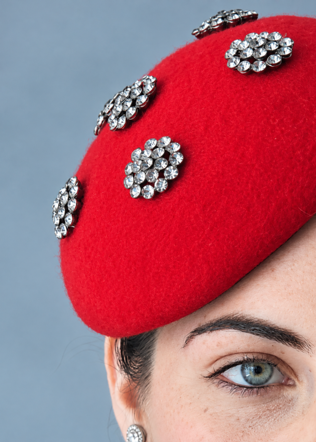 A close-up of a bright red felt Percher Ladybird hat