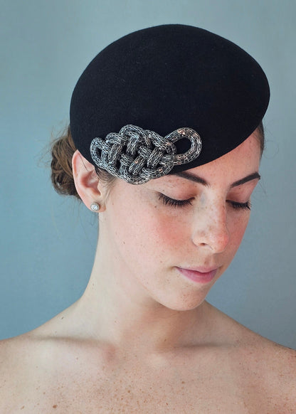 The Zoé felt percher hat with a silver chain-link decorative accent, photographed against a solid light blue background.