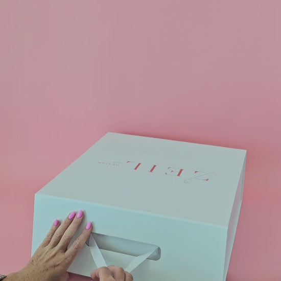 Video of MIA black boater hat being unboxed, revealing handcrafted open-weave design and red petersham ribbon detail